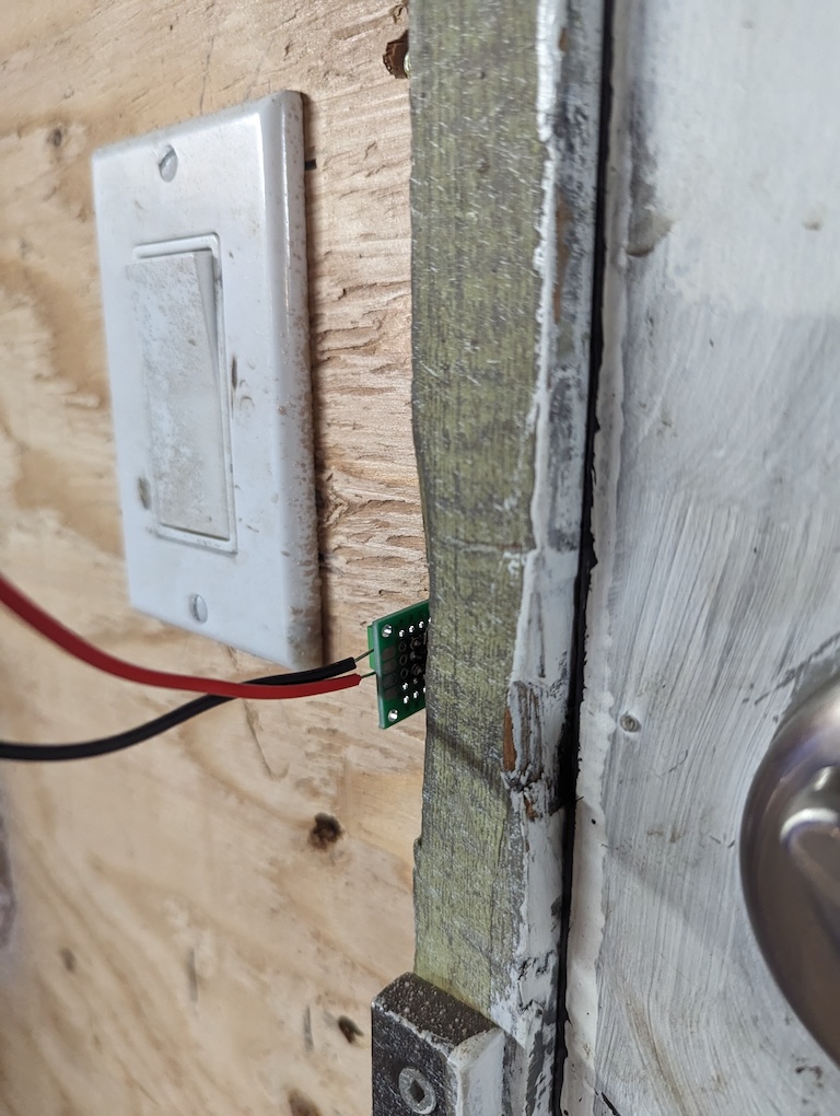 The pen-spring contraption installed in the door frame